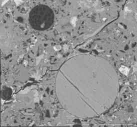 Figure 3-40:  Photographs.  Typical scanning electron microscope micrograph and X-ray analysis for hydrocalumite infilling air void.  This figure is comprised of two photographs labeled A and B.  Photograph A is a SEM micrograph and shows hydrocalumite in an air void, magnified 716 times.  Several unfilled air voids are also visible as well as a crack running through the paste.  Photograph B shows a typical spectrum from an X-ray analysis of a hydrocalumite deposit.  The spectrum several peaks labeled as aluminum and calcium, which indicates the presence of hydrocalumite deposits.