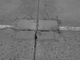  Figure 3-4 (b):  Photographs.  Typical distress manifestation observed on SD-090-019-002. This figure is comprised of two photographs of the roadway and are labeled A and B.  Photograph A is a close-up picture of map cracking with secondary material deposits filling the cracks.  A coin has been placed on the ground in the picture to give the viewer perspective.  Photograph B shows corner cracking at the joint intersection along with spalling that has been repaired with a concrete patch.