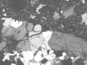 Figure 3-54 (c):  Photographs.  Petrographic micrograph of ASR gel in crack within coarse aggregate.  This figure is comprised of three micrographs, each one taken using a different light.  The micrographs show the interface between an aggregate particle and the surrounding paste.  A crack can be seen running along the interface.  This is most evident in the micrograph taken using the epifluorescent mode, where the aggregate appears black and the gel appears bright white.  Note that the gel deposit image was analyzed with the scanning electron microscope and the ASR "gel" in these images was found to be birefringent and crystalline. 