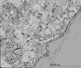  Figure 3-55 (a):  Photographs.  SEM micrograph of ettringite filling air voids and cracks.  This figure is comprised of two photographs labeled A and B.  In photograph A, ettringite is shown entrained in the air void and in the crack along the contact line between the cement paste and the coarse aggregate.  In photograph B, ettringite is shown entrained in the air void and in the crack along the contact line between the cement paste and the coarse aggregate.  Large relict cement is also visible in photograph B.  