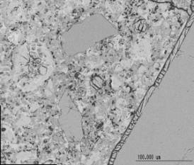  Figure 3-55 (b):  Photographs.  SEM micrograph of ettringite filling air voids and cracks.  This figure is comprised of two photographs labeled A and B.  In photograph A, ettringite is shown entrained in the air void and in the crack along the contact line between the cement paste and the coarse aggregate.  In photograph B, ettringite is shown entrained in the air void and in the crack along the contact line between the cement paste and the coarse aggregate.  Large relict cement is also visible in photograph B.  