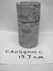  Figure 3-64 (a):  Photographs.  Photographs of core specimens analyzed from CA-058-141.  This figure is comprised of three photographs labeled A, B, and C.  Photograph A shows core CA058001C, which was taken from the road surface to a depth of 19.7 centimeters. The core is cracked about half way through.  Photograph B shows core CA058001D, which was taken from the road surface to a depth of 20.6 centimeters.  A small crack appears about one third of the way down.  Photograph C shows core CA058001E , which was taken from the road surface down to a depth of 19 centimeters.  The core has a significant crack about half way down where it appears some material is missing.  There is also a crack running down the side of the core.