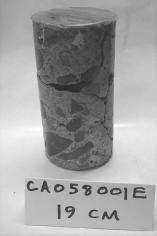  Figure 3-64 (c):  Photographs.  Photographs of core specimens analyzed from CA-058-141.  This figure is comprised of three photographs labeled A, B, and C.  Photograph A shows core CA058001C, which was taken from the road surface to a depth of 19.7 centimeters. The core is cracked about half way through.  Photograph B shows core CA058001D, which was taken from the road surface to a depth of 20.6 centimeters.  A small crack appears about one third of the way down.  Photograph C shows core CA058001E , which was taken from the road surface down to a depth of 19 centimeters.  The core has a significant crack about half way down where it appears some material is missing.  There is also a crack running down the side of the core.