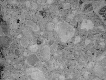  Figure 3-65 (b):  Photographs.  Stereo optical micrographs showing staining observed in core CA-058-141-001C.  This figure is comprised of two micrographs from core CA-058-141-001C labeled A and B.  Photograph A shows a felsic volcanic coarse aggregate particle with a sodium cobaltinitrite yellow stain within the particle.  Photograph B shows an unpolished cut surface that was stained.  Ettringite can be seen in the cracks and voids.