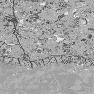  Figure 3-68 (b):  Photographs.  SEM spectra and micrograph from CA-058-141.  This figure has two photographs labeled A and B.  Photograph A is a typical spectrum from ASR gel adjacent to volcanic aggregate, which is pictured in Photograph B.  The peaks in the spectrum indicate the presence primarily of silicone and calcium, which are the key components in ASR gel.  Photograph B is a BSE image of ettringite filling a crack along the contact area between a coarse aggregate and the cement paste.  