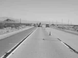 Figure 3-74 (a):  Photographs.  Typical conditions at CA-014-011.  This figure is comprised of two photographs labeled A and B.  Photograph A shows two lanes of highway from the project site.  In the picture, map cracking can be seen as well as transverse cracking and cracking along the longitudinal joint, both of which appear to have been previously patched.  Photograph B is a close up of observed map cracking.  