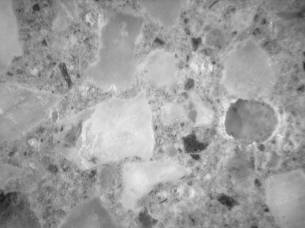 Figure 3-78 (b):  Photographs.  Results of staining test applied to core CA-058-011-001E.  This figure is comprised of two photographs labeled A and B.  Photograph A is the yellow sodium cobaltinitrite stain, which looks for ASR gel in cracks.  The gel is often associated with granitic coarse aggregate.  Photograph B is the barium chloride and potassium permanganate stain and shows ettringite filled air voids in purple and pink.  