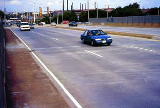 Figure 27. Photo. Bridge Deck Overlay, Wilmington, DE. This photo shows three lanes and a shoulder of a six-lane bridge.
