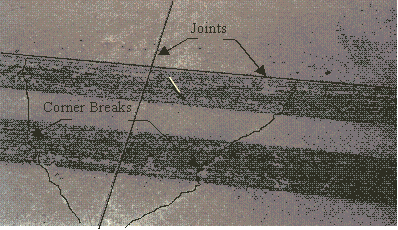 Figure 44.  Photo.  Photograph of corner breaks.  Joints and corner breaks are enhanced for clarity.  Two enhanced squiggly lines forming a V are the corner breaks.  Joints are the enhanced straight lines.