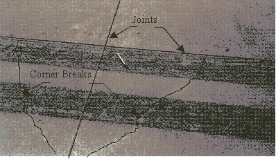 Figure 44.  Photo.  Photograph of corner breaks.  Joints and corner breaks are enhanced for clarity.  Two enhanced squiggly lines forming a V are the corner breaks.  Joints are the enhanced straight lines.