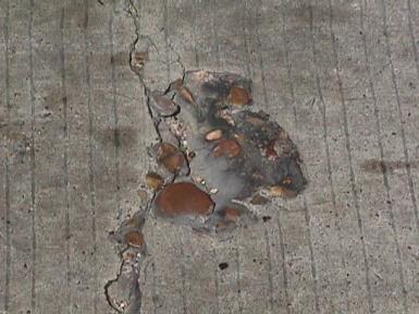 Figure 54.  Photo.  Round shaped aggregates at a spalled CRCP crack.  A spalled crack reveals round shaped aggregates in the concrete.