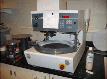 A turntable machine has a rotating disk-holder positioned horizontally on which interchangeable discs can be attached for grinding, lapping or polishing.  It has an overhead sample holder to keep the sample firmly pressed on the turning disks and a nozzle that dispenses water automatically for lubrication.