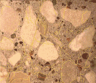 The lapped surface shows some cracks around the perimeter of coarse aggregate, while others cut through coarse aggregate. Reaction products are present in about a dozen locations throughout the paste.