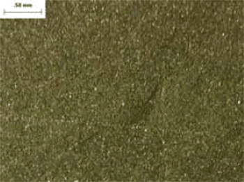 The photo shows a magnified view of a section of dark coarse aggregate. The texture of the aggregate is extremely fine-grained.