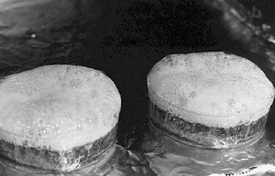 A closeup of the thin section samples in the oven shows that foam has developed on the surface of the sample trays during the progress of the vacuum-heating operation.