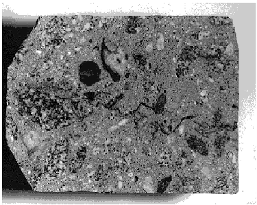    Photo shows a section through hardened concrete with the tortuous path of a plastic shrinkage crack. In this case the crack has not completely separated, showing how bridges of material form as the plastic concrete is stretched