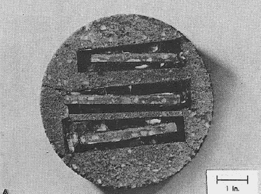 View shows the edges of three thin sections of top surfaces of a concrete core embedded in epoxy and repotted in mortar in a mold 152 millimeters in diameter and then re-sliced and finely lapped to allow examination of the vertical surface. In this case, the concrete was slightly etched with weak hydrochloric acid to delineate the depth of carbonation.