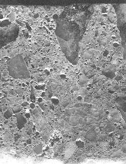 The concrete section shown has clusters of voids, probably resulting from a combination of excess air entraining admixture and incomplete mixing. Field width is 50 millimeters.