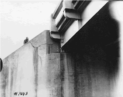 The upper portion of a bridge abutment wall is sheared by expansion of the bridge deck.