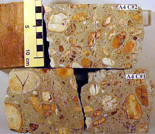 Photo. Polished surfaces of three concrete cores. The extensive cracking in the cores is shown. Photograph by Dr. P.E. Grattan-Bellew. This photo shows a cross-sectional view of three concrete cores. Only two cores are labeled, starting from the top, A-4 C#2, and A-4 C#1. A metric scale is shown next to the top core sample and illustrates that the diameter of the core is near 10 centimeters wide (4 inches). The aggregates in the samples are clearly shown in all three samples.