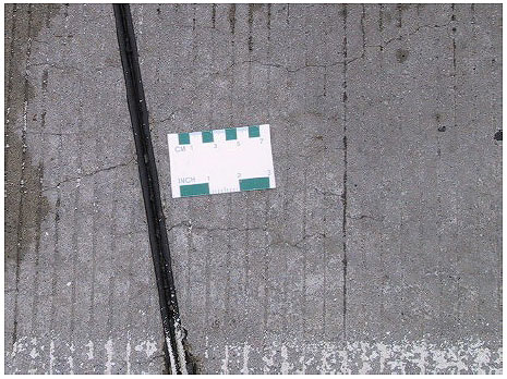 Figure 22.  Photo. Lackawanna Valley Industrial Highway Experimental Pavement-15 percent Class F Fly Ash (Mix #9)-May 2001.  Some cracking is visible near a joint in the pavement.