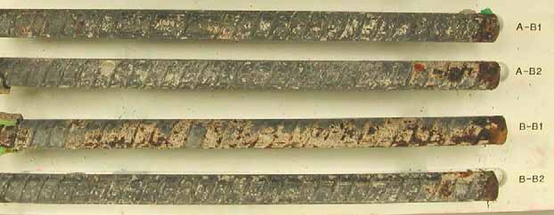 Figure 55. Slab #4 extracted rebars condition. Photo. Before autopsy, the bottom mat straight black bars show minor dark discoloration and concrete residue adhered on the surface. 