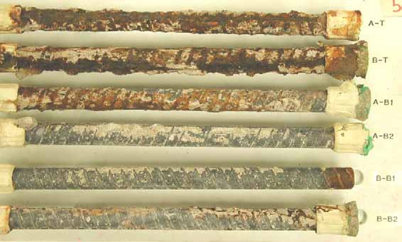 Figure 58. Slab #5 extracted rebars condition. Photo. Before autopsy, the two top mat straight black bars (A-T and B-T,) exhibit severe corrosion. The bottom mat four black bars (A-B1, A-B2, B-B1 and B-B2) show minor corrosion with some concrete residue. 