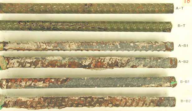 Figure 97. Slab #18 extracted rebars condition. Photo. Before autopsy, the two top mat straight ECRs (A-T and B-T) exhibit coating deterioration in the form of hairline coating cracks. The bottom mat black bars exhibit various levels of corrosion. 