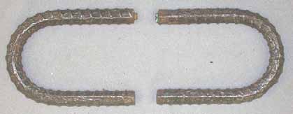 Figure 113. Slab #23 after autopsy. Photo. After autopsy, the cleaned top mat bent black bars and the bottom mat straight black bars exhibit severe corrosion damage. 