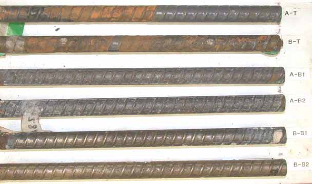 Figure 128. Slab #28 after autopsy. Photo. After autopsy, the top mat straight ECRs (A-T and B-T) show significant coating delamination and severe substrate corrosion. The cleaned bottom mat black bars exhibit either moderate corrosion damage (B-B1 and B-B2) or good condition (A-B1 and A-B2). 