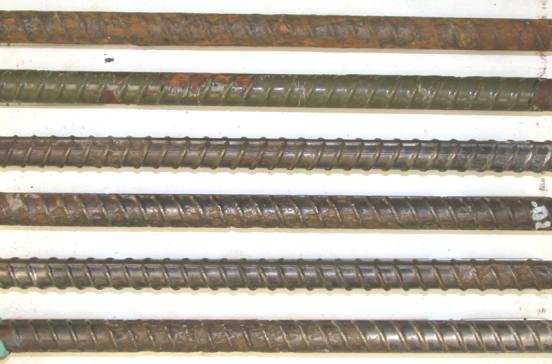 Figure 37. Photograph of autopsied bars extracted from slab #18 (ECR top-black bar bottom). Photo. The picture shows typical condition of poorly performed ECRs along with four bottom mat black bars. They were extracted from slab number eighteen. The top one is the most corroded, the second one has a few corrosion spots, the third, fourth and fifth still have some original color and shine and the bottom bar has some corrosion on the left and some shine on the right.