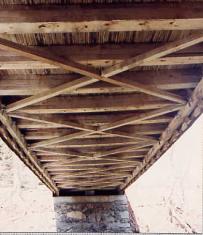 This picture shows a bracing system below the floor configured similar to the top lateral bracing. Diagonals cross the deck and tie into the ends of the floor beams. This system resists lateral bridge movement and helps resist wind loading.