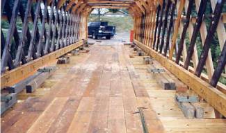 This picture shows the inside of a Town lattice truss bridge with the lattice sides and the basic floor system that features transverse floor beams (not visible) and longitudinal decking.