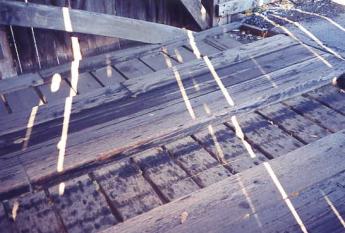 The picture shows interior floor decking with transverse planks underneath the longitudinal running planks that run with the axis of the bridge.