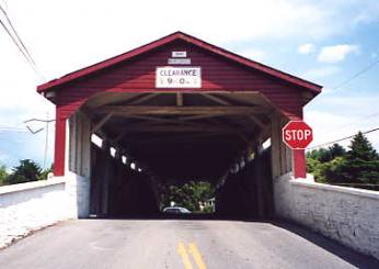 Some bridges contain a separate panel structure that begins before the actual trusses. This portal extension or shelter panel protects the ends of the trusses from wind-blown rain. The one shown in the picture also has a clearance sign and is tied into the concrete approach rails.