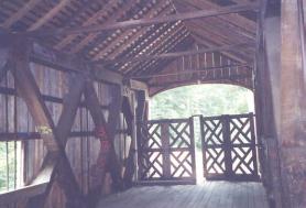 This interior view shows an extremely weak upper bracing system without a cross-lateral system or knee braces with thin and skimpy tie beams. The bridge has a latticed gate across the entrance.