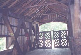 This interior view shows an extremely weak upper bracing system without a cross-lateral system or knee braces with thin and skimpy tie beams. The bridge has a latticed gate across the entrance.