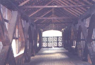 The picture shows the interior of an old original bridge. The trusses cannot be rated by modern specifications because American Chestnut is now such a rare species. ASTM procedures are used instead to determine the allowable stresses.