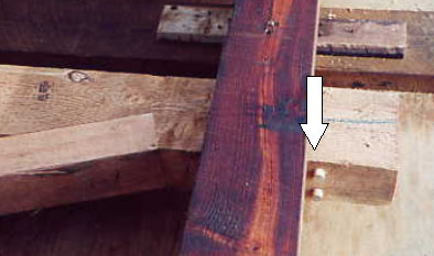 The white arrow in the picture points to two wooden dowels that attempt to fix corbel shear in the ends of a truss vertical, increasing the joint's vertical capacity by 15 percent.
