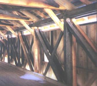 The picture shows the inside of a Long truss bridge with the dual wall diagonals as the compression members. The single diagonal elements are the counters to transfer additional compression forces, usually toe-nailed in place with light steel fasteners.