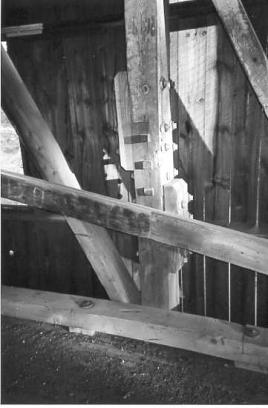 The picture shows a partial replacement of a damaged post. The original element is half-lapped with new outside splice timbers connected with bolts and three square shear keys to hold the splice tight.