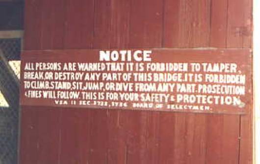 The picture shows a sign that indicates how protective covered bridge owners are about the historical significance and value of these treasures. The sign reads: "Notice. All persons are warned that it is forbidden to tamper, break or destroy any part of this bridge. It is forbidden to climb, stand, sit, jump, or dive from any part. Prosecution and fines will follow. This is for your safety and protection." The notice quotes an illegible law and section number followed by "Board of Selectmen"