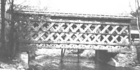 Figure 173 Side view of a typical covered bridge supported by Town lattice timber trusses. This is the Fuller Bridge in Montgomery, VT during its recent reconstruction. Photo.