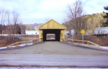 The picture shows the entry to the bridge with the railing configuration that has four vertical posts and one rail. The rails slant down to the ground at the end panel.