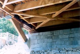 Figure 220 Underside of bridge showing floor beams, metal deck clips, bottom lateral bracing, arch springing area, and steel fabrication at the location where the arch passes through the bottom chord. Photo.