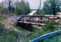 To solve the alignment problems, the bridge was relocated and the stream subsequently rerouted. The picture shows the first construction phase of building new standard stub abutments that bear directly on bedrock.