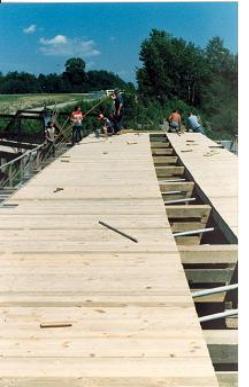 The picture shows workers laying vertical siding, but working horizontally before the truss was lifted for installation.