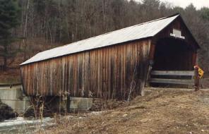 The picture shows the original 22-meter (72-foot)-long structure built in 1883. While the abutments are concrete, the approach rail is simple post and board fence.