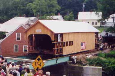 The picture shows moving the bridge on steel rollers supported on I-beams spanning the abutments. Wires attach to a capstan turned by oxen. The bridge still needs some finish siding and work completed at the portal.