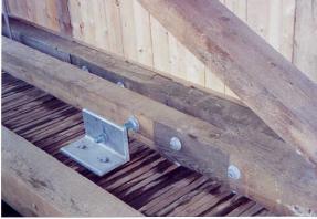 This picture shows the detail of connecting the sides of the bridge and the existing timber deck/steel beam superstructure. A steel L-shaped plate is bolted between the chord and the decking.